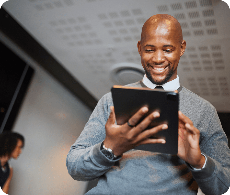 Man smiling while using a tablet