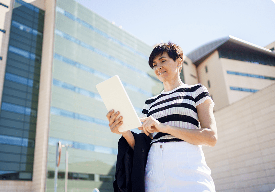 Woman using tablet outside modern building