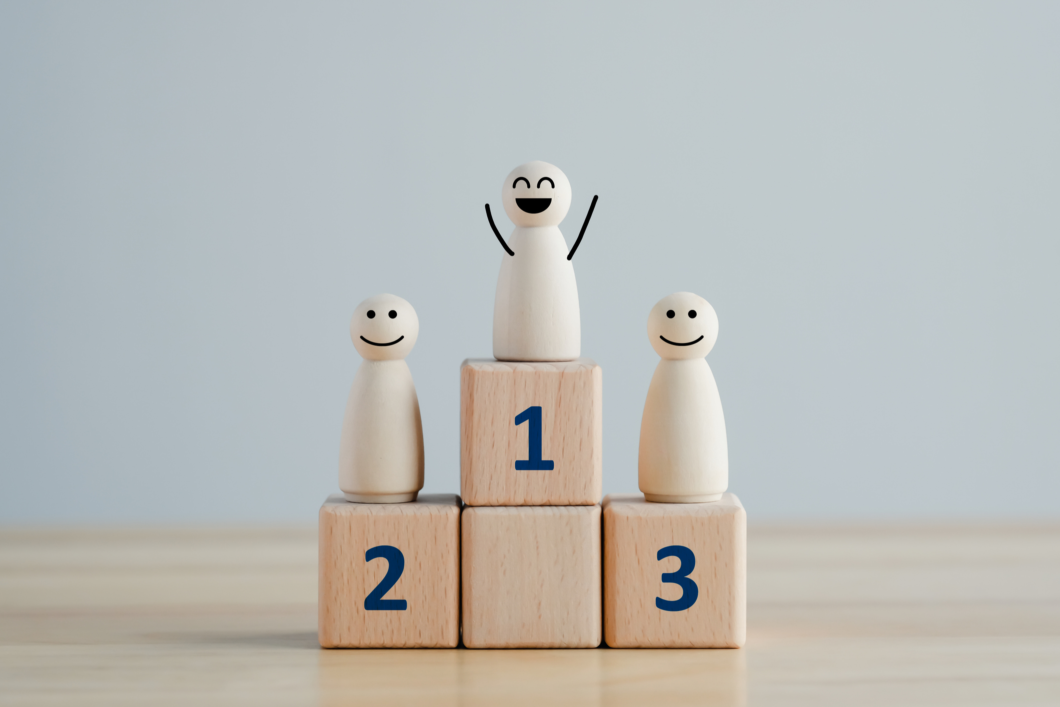 Smiling wooden figures on winners' podium