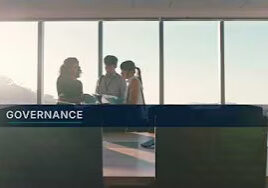 Governance team meeting in glass-walled office